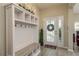 Stylish entryway with a built-in storage bench, decorative accents, and a welcoming front door at 12451 Nouveau Ave, Spring Hill, FL 34610