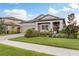Beautiful one-story home with a manicured lawn, lush landscaping, and a welcoming front porch area at 12451 Nouveau Ave, Spring Hill, FL 34610