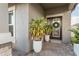 Close-up of a front door with decorative glass, a welcoming wreath, and potted plants at 12451 Nouveau Ave, Spring Hill, FL 34610