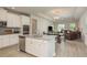Open-concept kitchen with white cabinets, granite countertops, stainless steel appliances, and breakfast bar seating at 12451 Nouveau Ave, Spring Hill, FL 34610