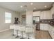 Bright open kitchen with an island, white cabinets, stainless steel appliances, and bar stool seating at 12451 Nouveau Ave, Spring Hill, FL 34610