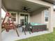 Enjoy outdoor living on this patio with a swing, seating area, and a ceiling fan for added comfort at 12451 Nouveau Ave, Spring Hill, FL 34610