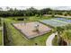 Community playground featuring various play structures surrounded by a safety fence and lush landscaping at 12451 Nouveau Ave, Spring Hill, FL 34610