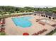 Overhead view of a large community pool with sun loungers, umbrellas, and a spacious pool deck area at 12451 Nouveau Ave, Spring Hill, FL 34610