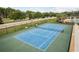 Beautiful community tennis court with green and blue surface, surrounded by well-maintained landscaping and fencing at 12451 Nouveau Ave, Spring Hill, FL 34610