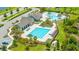 Aerial view of the community pool, clubhouse, lounge chairs, and palm trees providing a luxurious resort experience at 12652 Shetland Walk Dr, Lithia, FL 33547