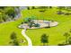 Aerial view of a playground with slides and swings in a well-maintained community with green grass and small pond at 12652 Shetland Walk Dr, Lithia, FL 33547