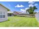Spacious backyard with lush lawn, wooden fence, screened porch, and screened pool, perfect for outdoor entertaining at 13602 Fawn Ridge Blvd, Tampa, FL 33626
