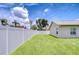 Well-maintained backyard featuring a lush green lawn, surrounded by a white vinyl fence for privacy and security at 13602 Fawn Ridge Blvd, Tampa, FL 33626
