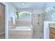Bright bathroom with soaking tub with shower and decorative glass block window at 13602 Fawn Ridge Blvd, Tampa, FL 33626