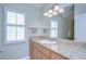 Bathroom featuring granite countertop, window with shutters, vanity, and decorative lighting at 13602 Fawn Ridge Blvd, Tampa, FL 33626