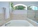 Bright bathroom with soaking tub with shower and decorative glass block window at 13602 Fawn Ridge Blvd, Tampa, FL 33626