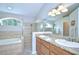 Bathroom features a walk in shower, soaking tub, and a double sink vanity with granite counters at 13602 Fawn Ridge Blvd, Tampa, FL 33626
