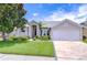 Beautiful single-Gathering home with a well-manicured lawn, lush shrubbery, and attached two car garage at 13602 Fawn Ridge Blvd, Tampa, FL 33626
