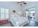 Cozy bedroom featuring a vaulted ceiling, beach-themed decor, and access to the lanai at 13602 Fawn Ridge Blvd, Tampa, FL 33626