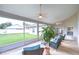 Relaxing screened-in patio with wicker furniture, ceiling fans, and views of the landscaped backyard at 13602 Fawn Ridge Blvd, Tampa, FL 33626