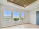 Bright bedroom with light wood floors, lake view, and striking wood ceiling at 1583 Running Tide Pl, Sarasota, FL 34240