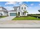 Charming two-story home featuring manicured landscaping, a paved driveway, and a teal garage door at 1583 Running Tide Pl, Sarasota, FL 34240