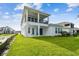 Back exterior showcasing a white facade and manicured lawn at 1583 Running Tide Pl, Sarasota, FL 34240