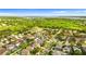 Aerial view of a quiet residential area near a lush green space and a large, shimmering lake at 1631 Shady Oaks Dr, Oldsmar, FL 34677