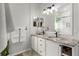 Bathroom featuring dual sinks, granite countertops, and a walk-in shower at 1631 Shady Oaks Dr, Oldsmar, FL 34677