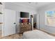 Well-lit bedroom featuring a dresser with a mounted TV and a ceiling fan and a view into the ensuite bathroom at 1631 Shady Oaks Dr, Oldsmar, FL 34677