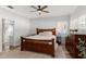 Bedroom with a wooden bed frame, a ceiling fan, and natural light from shuttered windows at 1631 Shady Oaks Dr, Oldsmar, FL 34677