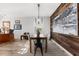 Dining room with modern chandelier, rustic wood wall and view into adjacent office at 1631 Shady Oaks Dr, Oldsmar, FL 34677