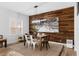 Dining room featuring a wood accent wall, modern chandelier, and large picture window at 1631 Shady Oaks Dr, Oldsmar, FL 34677