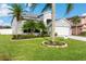 Lush lawn with manicured flowerbeds, and a vibrant green lawn enhance the home's curb appeal at 1631 Shady Oaks Dr, Oldsmar, FL 34677