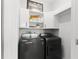 Functional laundry room featuring a front-load washer and dryer with bright white cabinets above at 1631 Shady Oaks Dr, Oldsmar, FL 34677