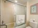 Clean bathroom with a shower-tub combo, framed glass door, and neutral finishes at 1712 Hammock Pine Blvd # 1712, Clearwater, FL 33761