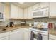 Well-equipped kitchen with white cabinets, neutral countertops, and modern appliances at 1712 Hammock Pine Blvd # 1712, Clearwater, FL 33761