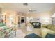 Open-concept living area with floral chairs, sofas, and a glass coffee table at 1712 Hammock Pine Blvd # 1712, Clearwater, FL 33761