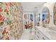 Colorful bathroom with custom wallpaper and shower curtain, with a marble vanity at 1802 Regal Mist Loop, Trinity, FL 34655