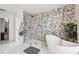 Modern bathroom featuring a glass shower, a soaking tub, and a black marble accent wall at 1802 Regal Mist Loop, Trinity, FL 34655