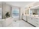 Bright, modern bathroom with double vanity, soaking tub, and marble accent wall at 1802 Regal Mist Loop, Trinity, FL 34655