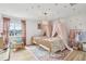 Shared bedroom with two twin beds with pink canopy nets and starry ceilings at 1802 Regal Mist Loop, Trinity, FL 34655