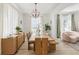 Bright dining room features hardwood floors, a modern light fixture, and a long table with seating at 1802 Regal Mist Loop, Trinity, FL 34655