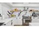 Modern kitchen with white cabinets, stainless steel appliances, and open shelving for stylish storage at 1802 Regal Mist Loop, Trinity, FL 34655