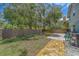 This backyard features a travertine patio and a privacy fence surrounded by a mature shade tree at 1830 Springwood N Cir, Clearwater, FL 33763