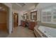 Bright bathroom features double sinks, wood cabinets, tiled floors, and a soaking tub with plantation shutters at 1830 Springwood N Cir, Clearwater, FL 33763
