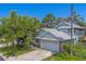 Charming home featuring well-maintained landscaping, mature trees, and an attached two-car garage at 1830 Springwood N Cir, Clearwater, FL 33763