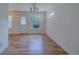 Bright living room features wood-look flooring, neutral paint, and plentiful natural light from multiple windows at 1830 Springwood N Cir, Clearwater, FL 33763