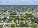 Aerial view of a home situated in a residential area surrounded by mature trees and greenery at 1843 Berg Rd, Holiday, FL 34690