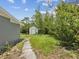 Spacious backyard with shed, landscaping, grass, and stone path provides privacy and tranquility at 1843 Berg Rd, Holiday, FL 34690