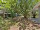Large, shaded backyard featuring mature trees, landscaping, shed, and partial view of covered patio at 1843 Berg Rd, Holiday, FL 34690
