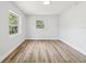 Spacious bedroom with ample natural light, complemented by wood-look floors and neutral walls at 1843 Berg Rd, Holiday, FL 34690