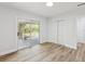 Bright bedroom with wood floors, a closet and a sliding glass door leading to a patio at 1843 Berg Rd, Holiday, FL 34690