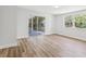 Well-lit bedroom with wood floors, a window and a sliding glass door leading to a patio at 1843 Berg Rd, Holiday, FL 34690